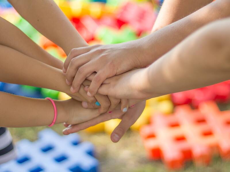 Kinderhände übereinander gelegt.