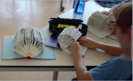 Schüler falten aus Büchern Igel.