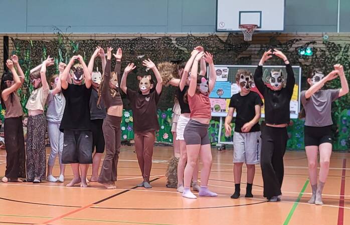 Kinder im Tierkostüm tanzen das Waldballett.