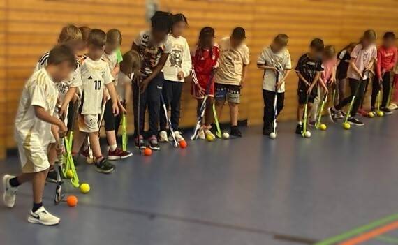Kinder probieren Hockey aus.