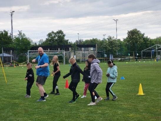 Herr Stemp und Kinder führen Tanz vor.