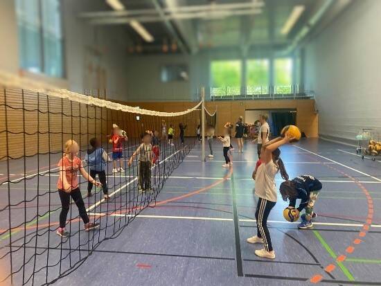 Kinder spielen Volleyball.