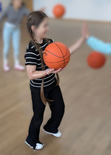 Kind spielt Basketball und gibt jemanden ein High-Five.